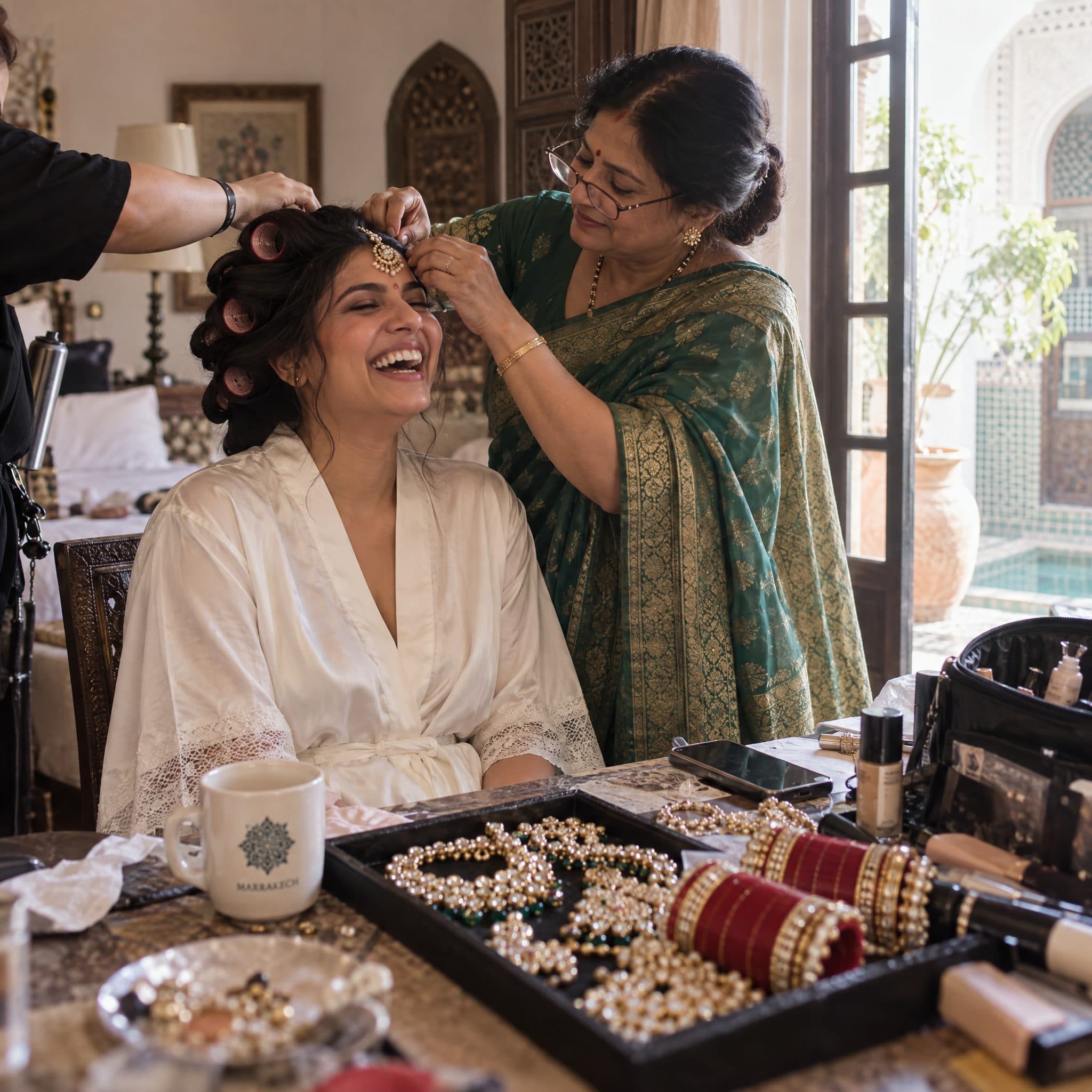 Bride having her hair set by her mother in a palace suite on the morning of the wedding